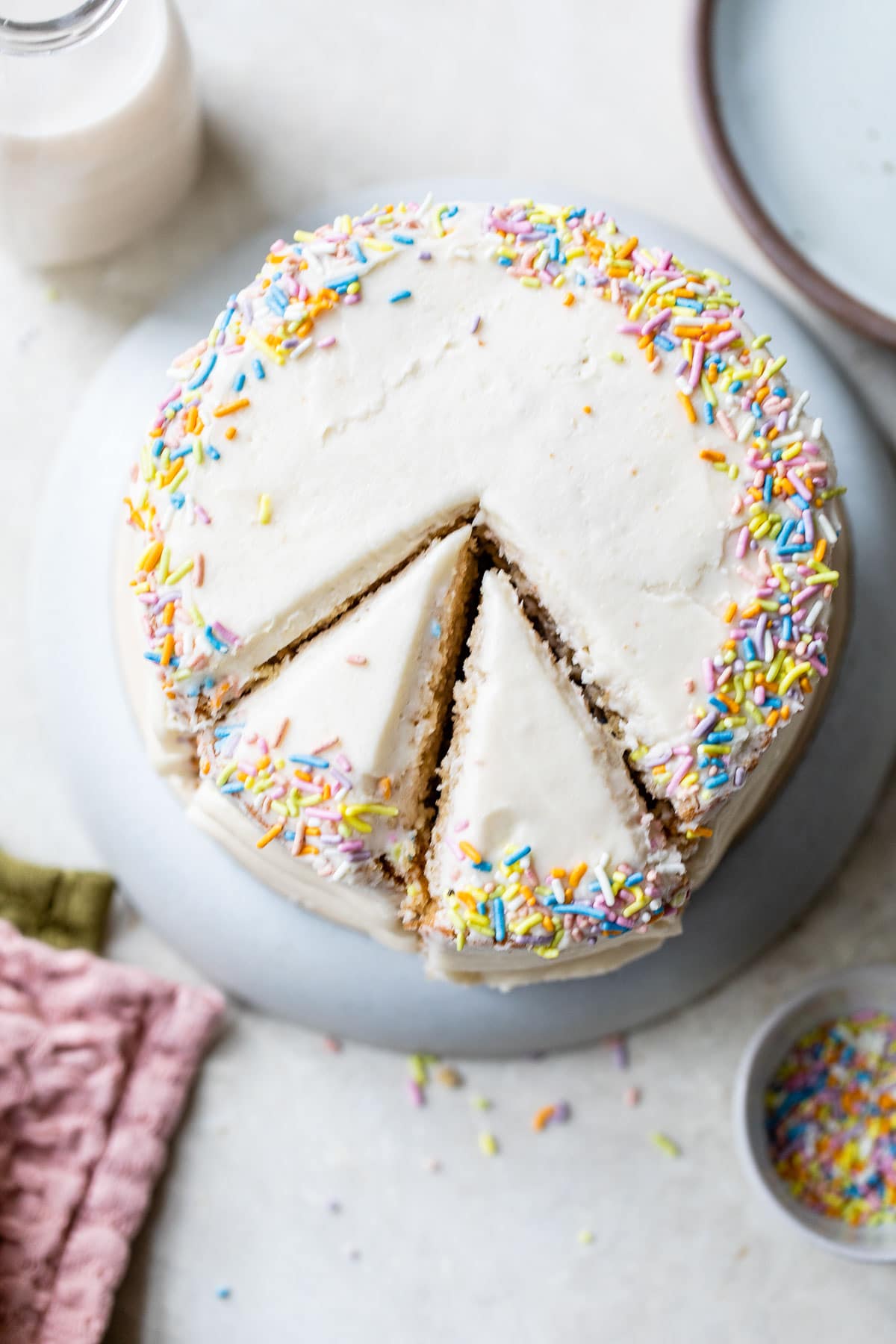 overhead photo of a vanilla cake topped with sprinkles
