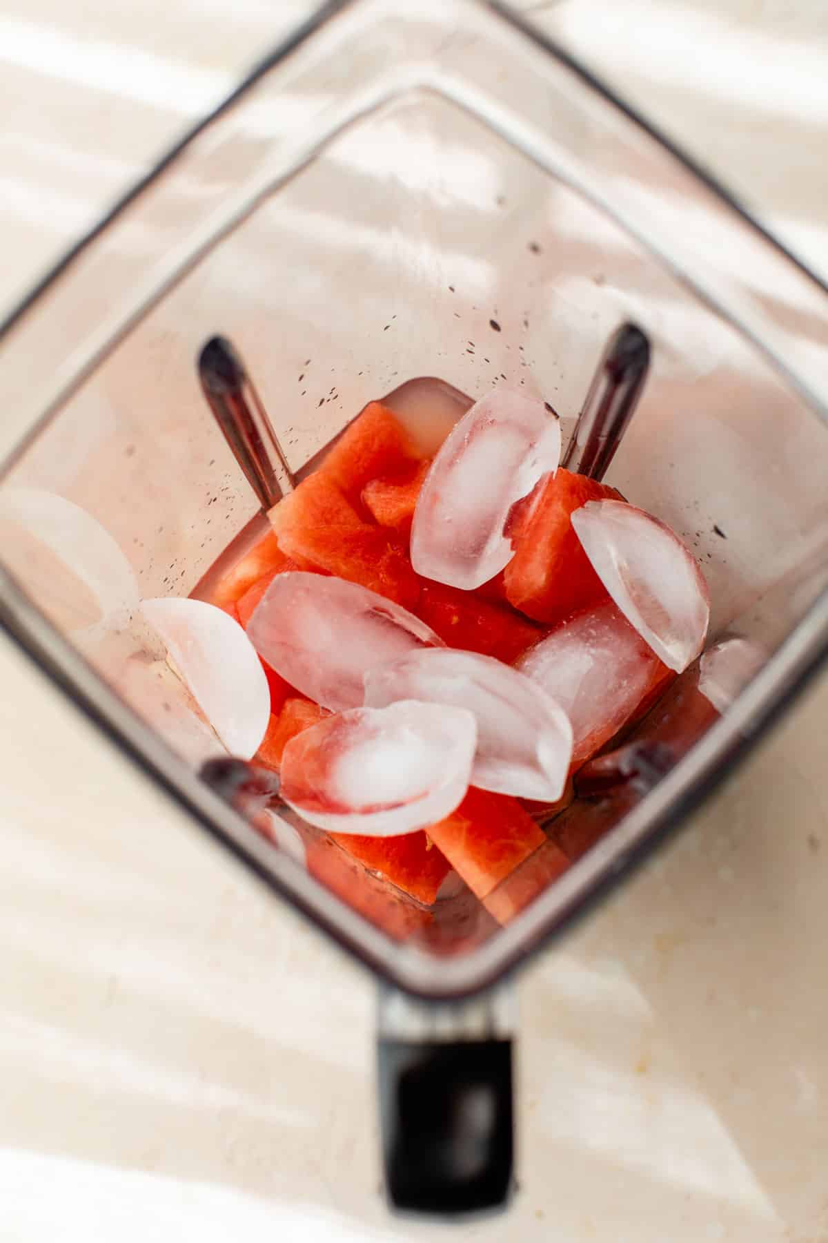 ice and other ingredients added to the blender with watermelon