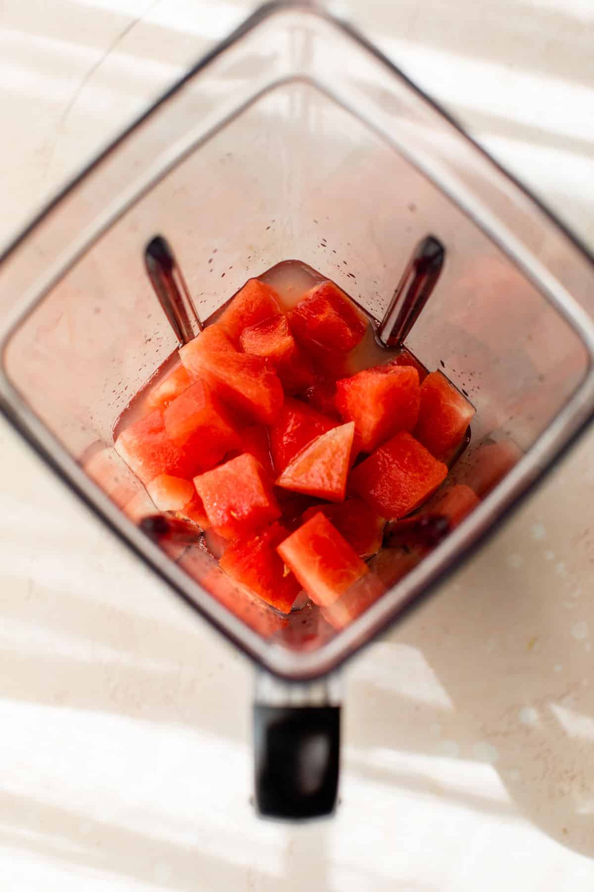 cubed watermelon added to a blender