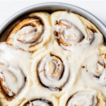 cinnamon rolls in a cake pan with text overlay